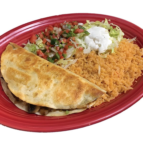 A La Carreta quesadilla with rice, pico de gallo, shredded lettuce, and sour cream on a red plate.
