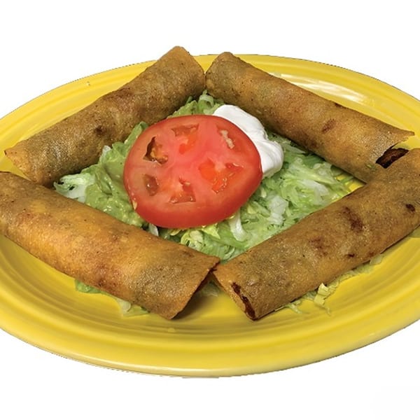 Four golden-brown taquitos on a yellow plate with shredded lettuce, a tomato slice, and sour cream.