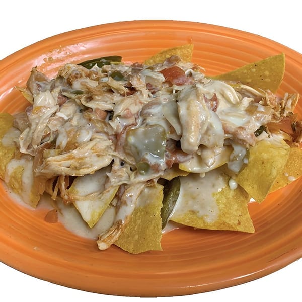 La Carreta's chicken nachos, topped with creamy white sauce, diced tomatoes, and green peppers.